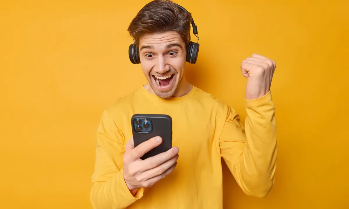 Hombre jugando un juego para ganar dinero en su celular.