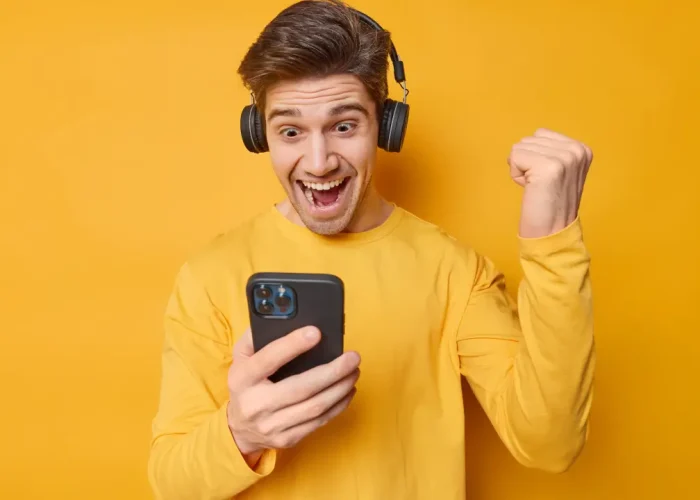 Hombre jugando un juego para ganar dinero en su celular.